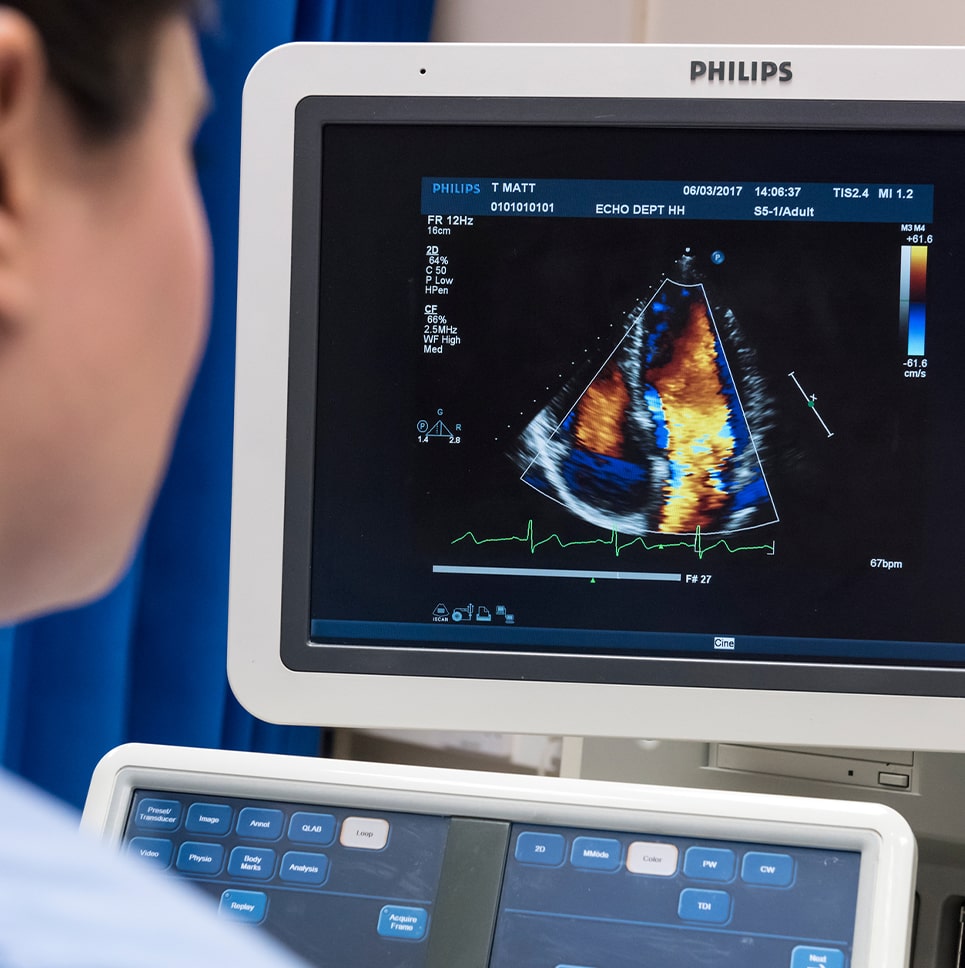 A woman is looking at a meical image on a monitor.